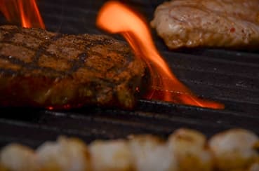 Steaks with flames on the grill